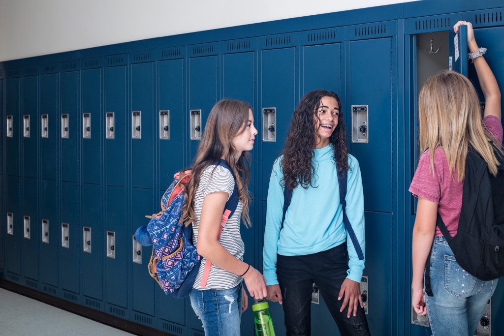 Junior students are talking with each other besides school lockers